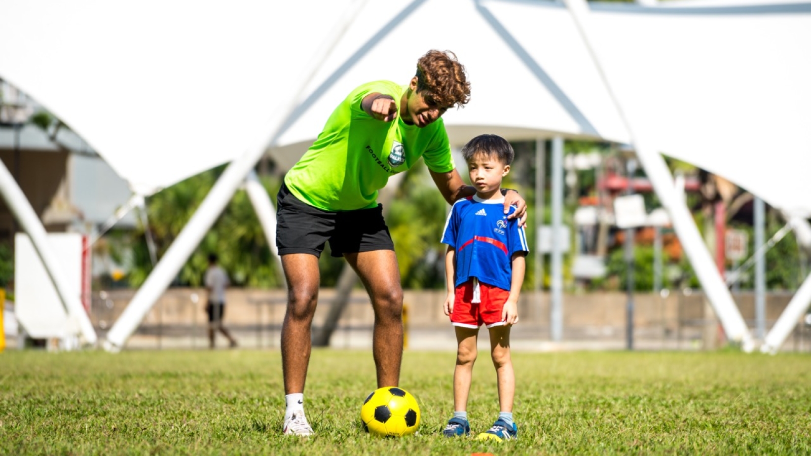 football coach guiding kids on where to kick the ball towards