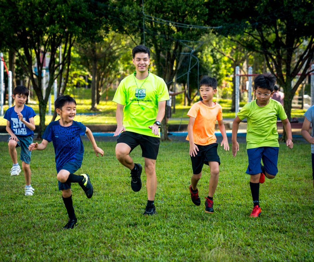 soccer coach and students doing foot drills together