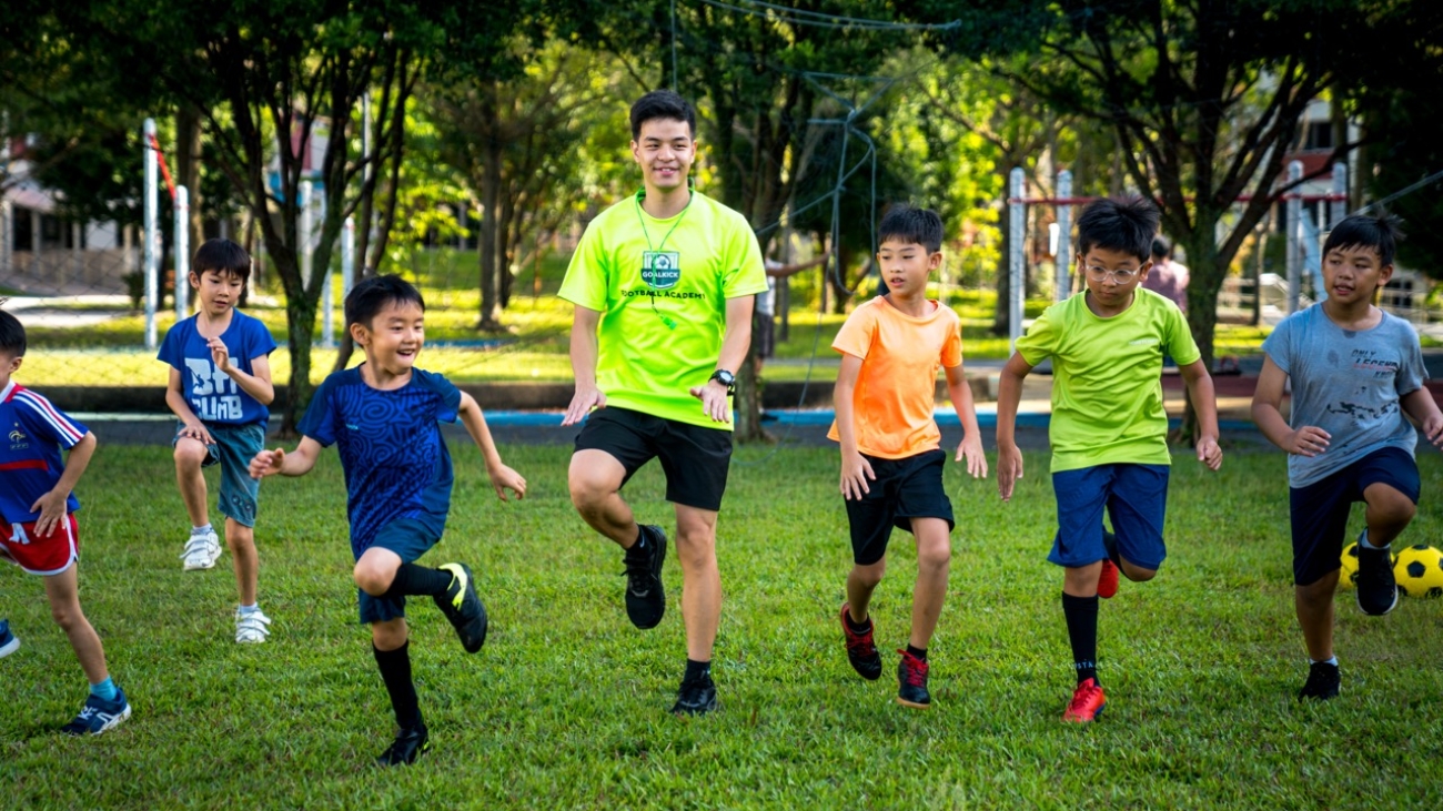 soccer coach and students doing foot drills together