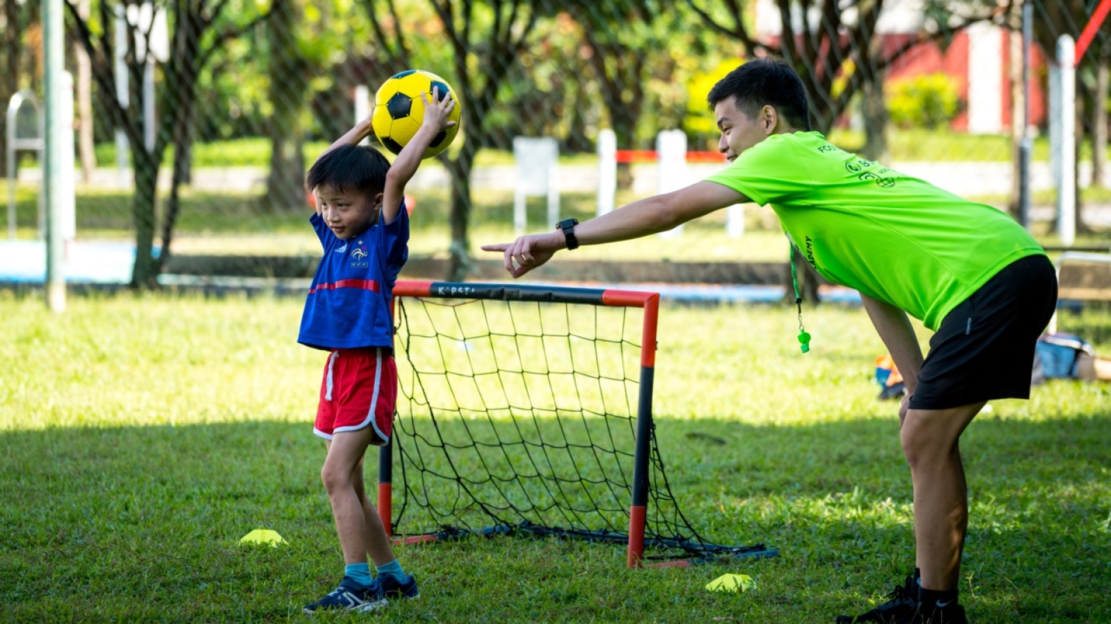 football coach guiding goalkeeper on how to throw-in